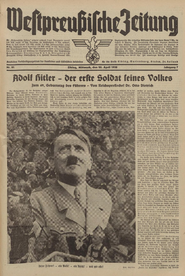Adolf Hitler, in einem schwarzen Anzug und weißem Hemd, steht vor einer Menge auf der Titelseite einer deutschen Zeitung mit der Schlagzeile "Adolf Hitler - Der Erte Soldat Feines Volkes".
