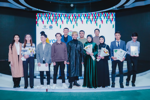 Eine Gruppe von Menschen auf einer Bühne, jeder hält einen Blumenstrauß und Urkunden in den Händen, im Hintergrund ein Schild mit der Aufschrift "Jugend-Solar-Awards 2019".