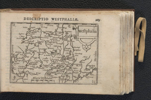 Ein aufgeschlagenes Buch, das eine detaillierte Karte der geografischen Merkmale Westphalens zeigt, liegt auf einer schwarzen Oberfläche.