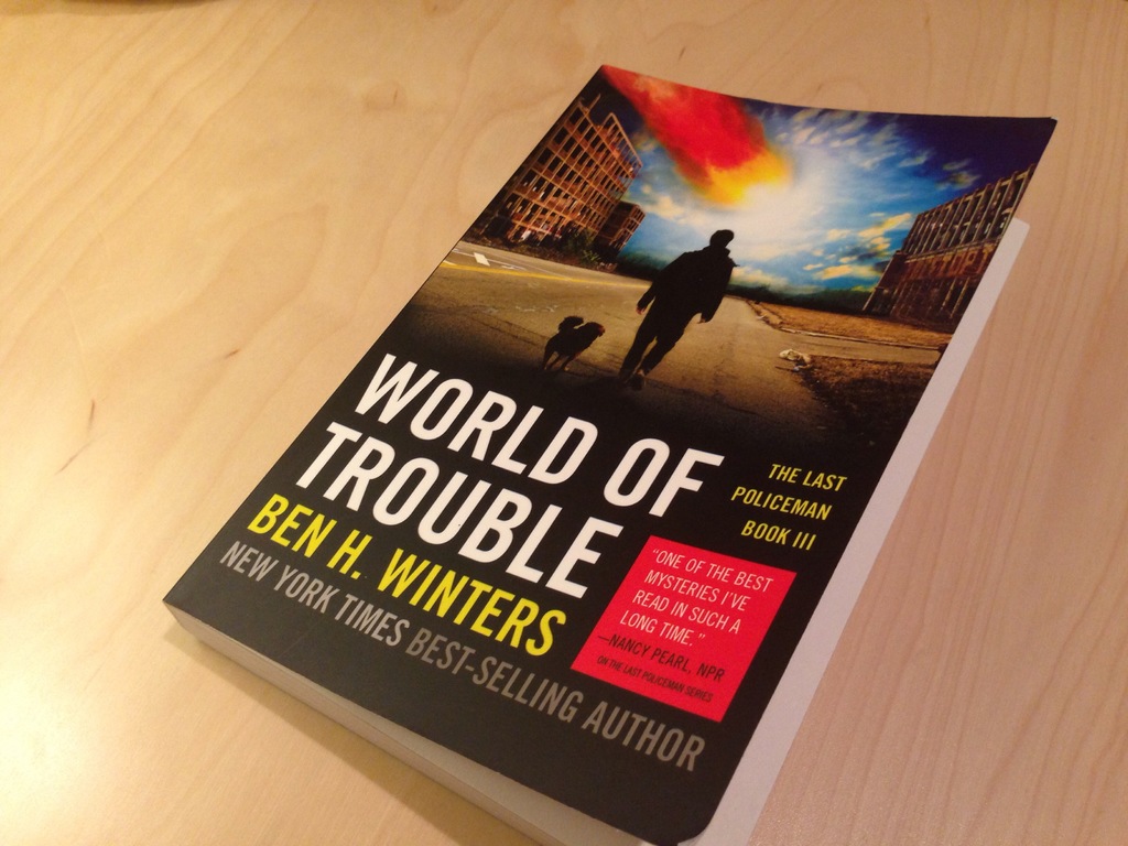 Ein Buch mit dem Titel "Welt der Probleme", das ein Bild eines Mannes und eines Hundes zeigt, das auf einem Tisch liegt.