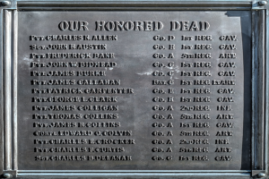 Eine Metallgedenktafel an der Außenseite eines Gebäudes mit der Inschrift "Unseren Ehrenvollen Toten", die wahrscheinlich verstorbene Personen gedenkt.