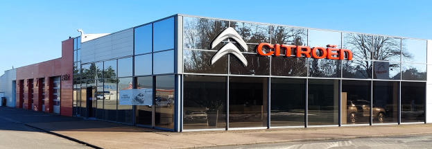 Glasswandiges Citroën-Autohaus mit Straße davor und einem klaren blauen Himmel im Hintergrund.