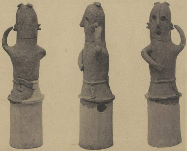 Drei Terrakottastatuen eines Mannes und einer Frau in traditioneller Kleidung, die eng beieinanderstehen und sich um die Schulter des Mannes und ihre Hände halten.
