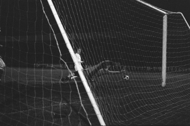 Ein Fußballer in einem Schwarz-Weiß-Foto hält den Ball