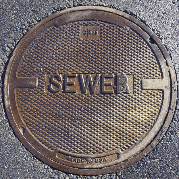 Metall-Schachtobjekt auf der Straße mit der Aufschrift "Kanal"