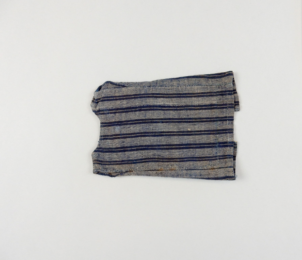 Stück Stoff mit gleichmäßig beabstandeten horizontalen blauen und weißen Streifen auf einer weißen Oberfläche, Stoff leicht zerknittert mit abgenutztem Erscheinungsbild.