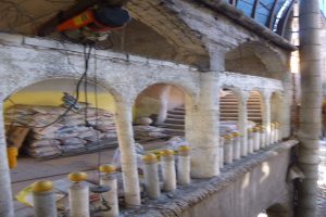 Altes Gebäude mit Bogengang, Säulen und Treppen undergoes Renovierung, featuring scattered Tools, Materials, and scattered objects including bags.