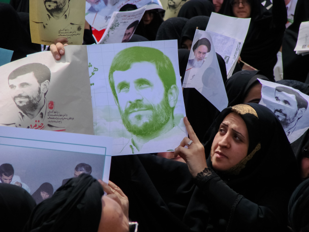 Eine Gruppe iranischer Frauen in schwarzer Kleidung, einige mit Brille, halten Fotos von Präsident Mahmoud Ahmadinejad während einer Demonstration in Tehran hoch.