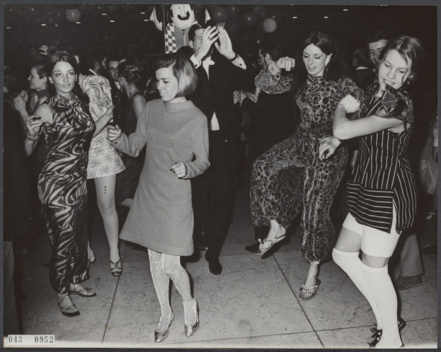 Schwarzes und weißes Bild von Frauen, die auf einer beleuchteten Tanzfläche tanzen, umgeben von Ballons mit Text unten.