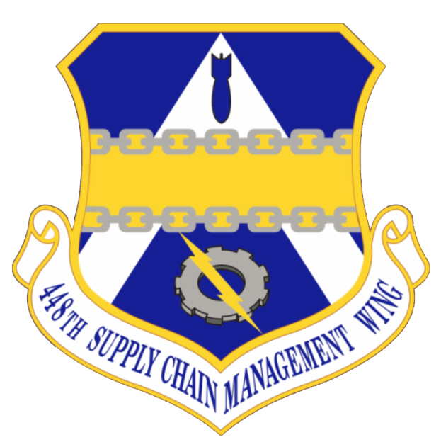 Ein Schild mit einem blauen Hintergrund, einem weißen Stern in der Mitte und einem weißen Banner mit der Aufschrift 'Supply Chain Management' in blau, umgeben von einem weißen Rand, mit der fettgedruckten Schrift '48th Supply Chain Management Wing'
