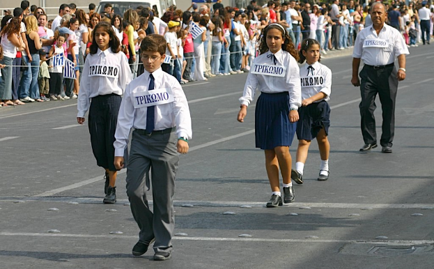 Menschen auf einer Straße bei einem Ereignis, tragen Abzeichen, mit einer großen Menge drumherum.