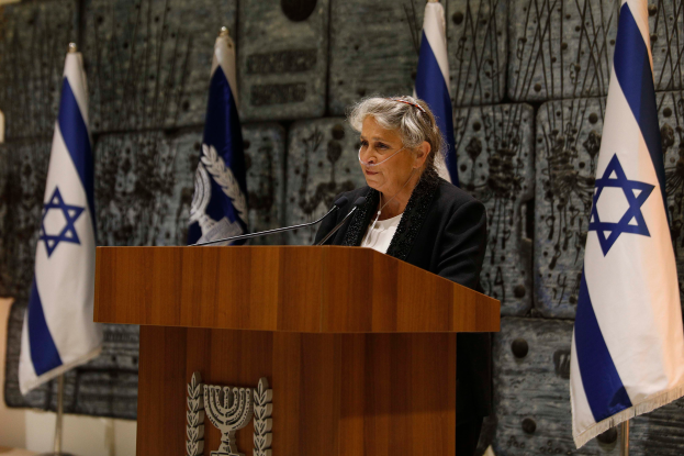 Israeli Premierminister Yitzhak Rabin in einem schwarzen und weißen Kleid vor israelischen Flaggen stehend und vor einem Podium mit mehreren Mikrofonen sprechend, während er an einer Pressekonferenz in Jerusalem spricht.